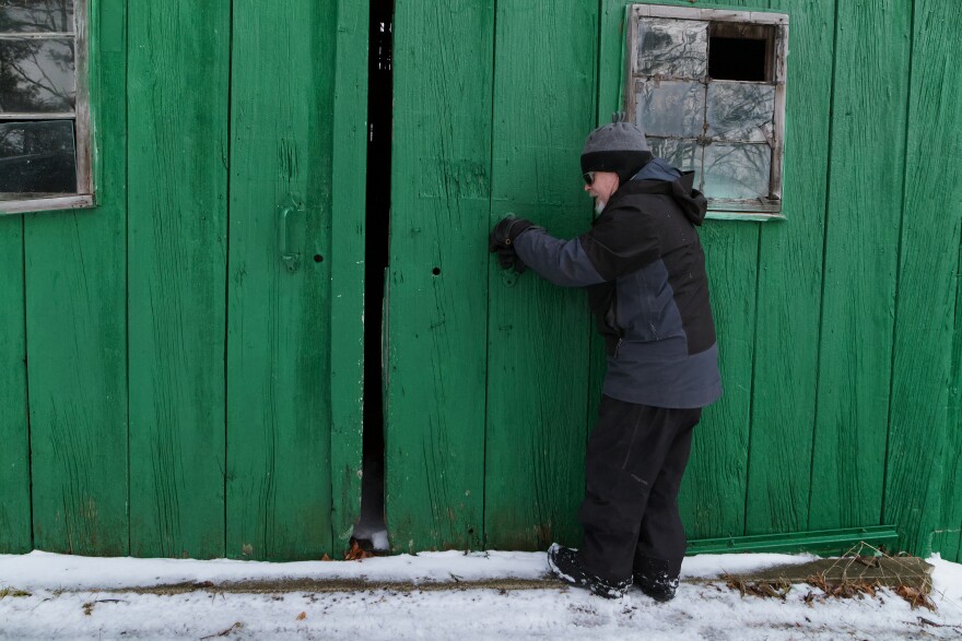 David Weeks opens the barn door on his farm, La Casa Verde, in Cedar.