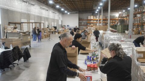 Employees with the Oregon Office of Resilience and Emergency Management pack food boxes at a warehouse in Salem as part of a training to see how they can respond to future food emergencies.