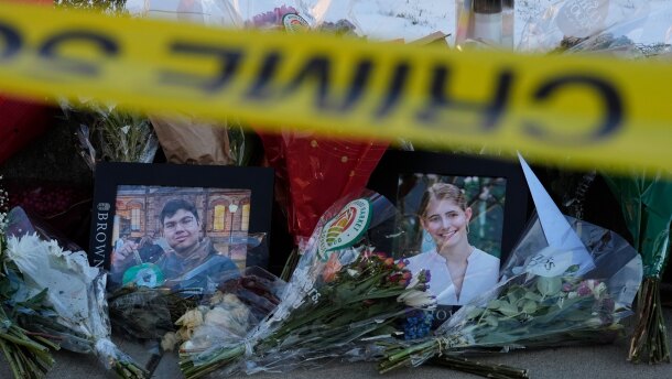 Photos of Brown University shooting victims MukhammadAziz Umurzokov, left, and Ella Cook, are seen amongst flowers at a makeshift memorial outside the Engineering Research Center, Tuesday, Dec. 16, 2025, in Providence, R.I. (AP Photo/Robert F. Bukaty)