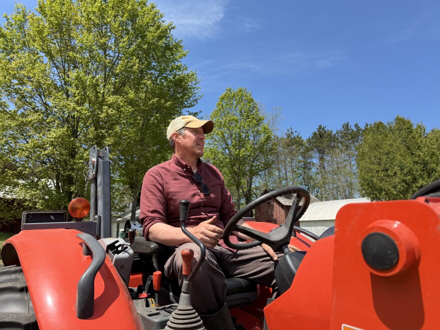 Adam Brown sits on a tractor at the Great Lakes Incubator Farm. He teaches students at the farm and says there needs to be more training programs like this to support an aging farmer population. (Photo: Vivian La/IPR News)