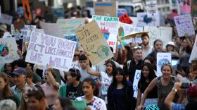 Young activists and their supporters hold signs as they march during a Global Climate Strike demonstration in 2019.