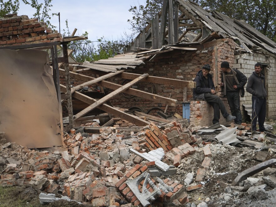 Residents stand next to a building that was damaged in the night, following Russian shelling in Komyshevakha, Zaporizhzhia region, Ukraine, Monday.