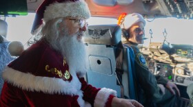 Santa Claus talks to the crew with the 144th Airlift Squadron en route to Bethel, Alaska, in support of Operation Santa Claus, Nov. 15, 2023. Operation Santa Claus is the AKNG’s yearly community outreach program that provides gifts and Christmas cheer to children in remote communities across the state. (U.S. Army National Guard photo by Sgt. Marc Marmeto).