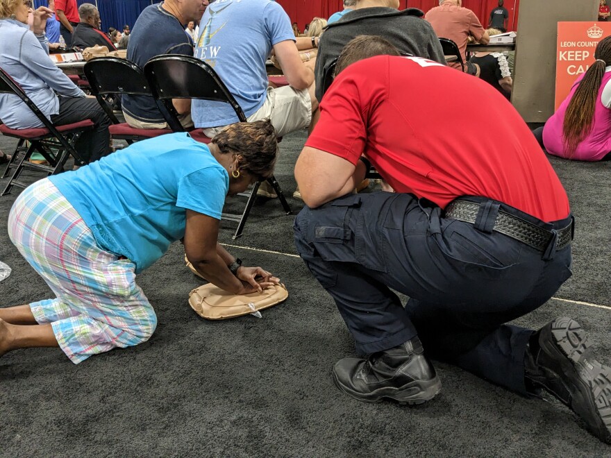 A Press the Chest participant gets some pointers from a Leon County EMS staffer as she attempts a mock resuscitation.