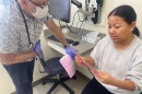 Dr. John Snyder of Amherst Pediatrics gives Tenzin Dekey information about vaccines for her son.