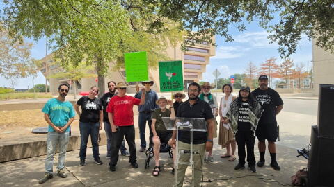Supporters with the National Alliance Against Racist & Political Repression in Dallas stage their speech across the street from Dallas City Hall after being told to relocate.
