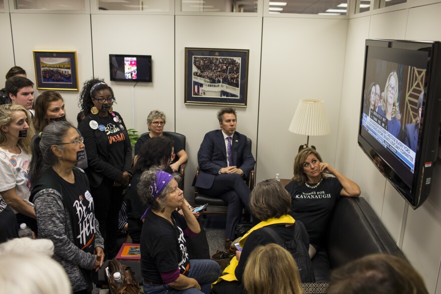 Protesters and supporters of Brett Kavanaugh's nomination watch Christine Blasey Ford's testimony from Sen. Chuck Grassley's office in Washington, D.C.
