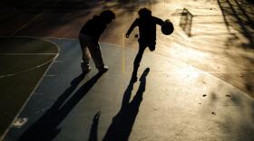 Young boys play basketball on a playground in the Hamilton Heights neighborhood of Manhattan in New York City on November 19, 2025. (Charly Triballeau/AFP via Getty Images)