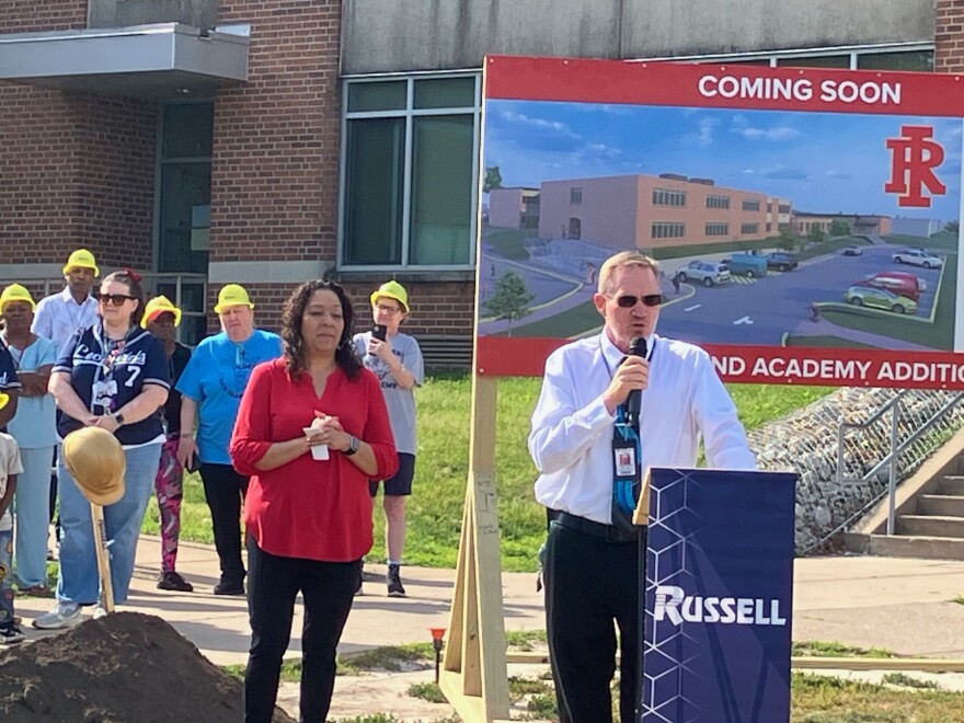 Rock Island Academy principal Thomas Ryan speaks at the Thursday groundbreaking, May 28, as Rock Island-Milan Board of Education member Isabel Pena (in red) looks on.