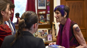This photo provided by the Office of Congresswoman Rosa DeLauro shows Connecticut U.S. Rep. Rosa DeLauro, right, donning a tattoo, as she talks with interns, Friday, July 28, 2023, in Washington. DeLauro has stood out for years with her colorful clothing and hairstyle, but it took one of her six grandchildren to finally convince the 80-year-old lawmaker to complement her fashion-forward look with a tattoo.