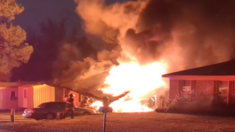 A residential house on fire as first responders attempt to control the fire.