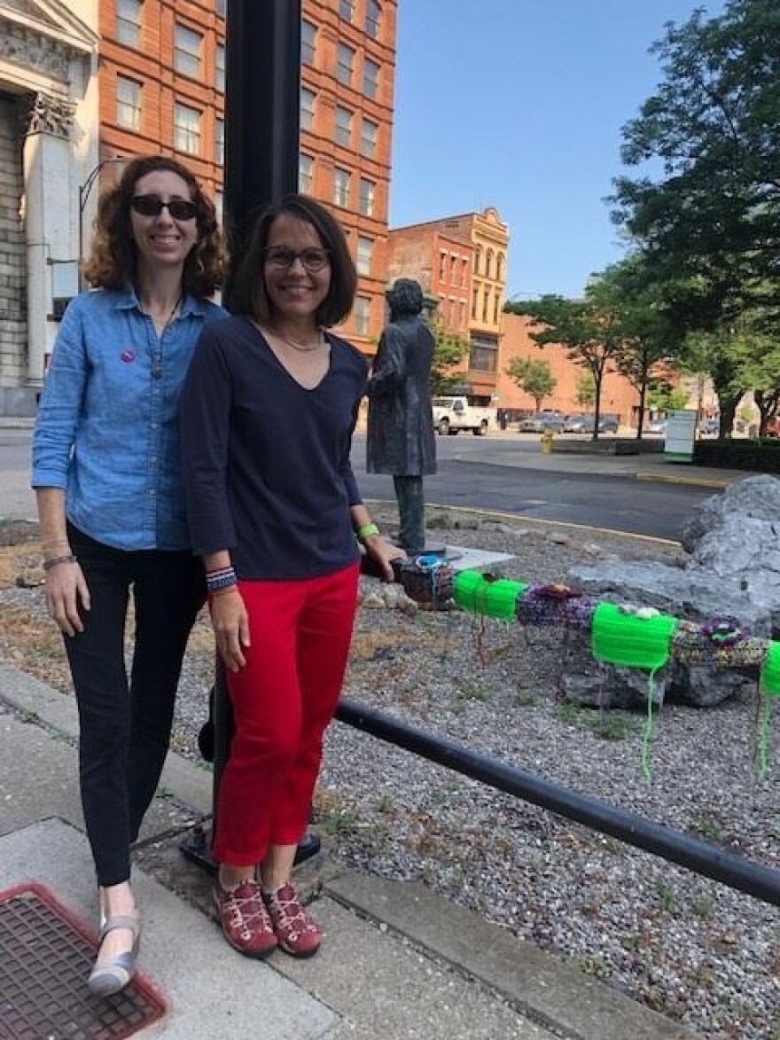 Hinda Mandell, left, and Juilee Decker stand in front of knitted sample squares at the future site of their Corinthian Hall Craft Intervention.