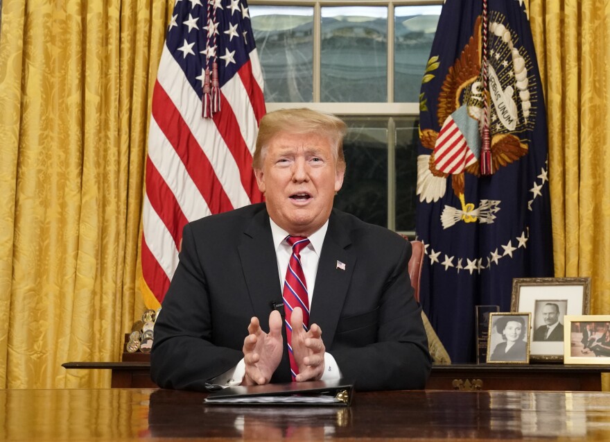 As seen from a window outside the Oval Office, President Donald Trump gives a prime-time address about border security Tuesday, Jan. 8, 2018, at the White House in Washington.