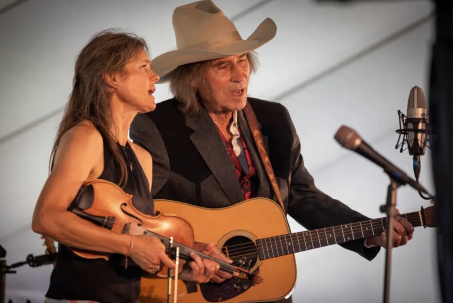 Old-time fiddler Heidi Clare and bluegrass musician Ron Thomason sing during a festival.