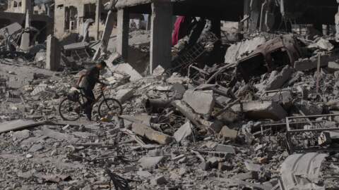 A man pushes his bicycle through rubble in Gaza City, Sunday, Oct. 12, 2025, after Israel and Hamas agreed to a pause in their war and the release of the remaining hostages. (Jehad Alshrafi/AP)