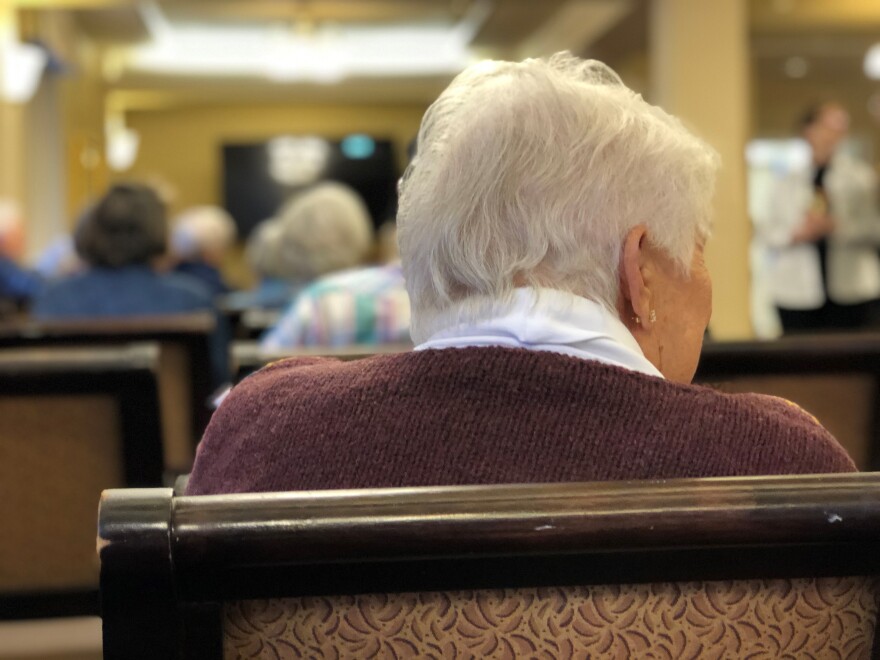 Back of senior's head watching a film.