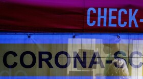 A woman is tested by a medical worker in a mobile COVID-19 test center in front of the zoo in Kronberg, Germany, on Jan. 22, 2022. (Michael Probst/AP)