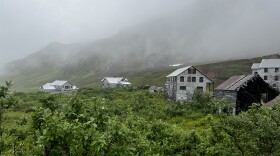 Buildings from a former mine sit in fog.