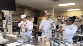 Holyoke Community College student Kasey Davis (far right) speaks with executive chef Andre Fuehr about a recipe.