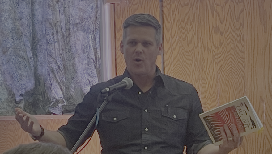 Panhandle poet Seth Wieck with a copy of his latest collection, Call Out Coyote, published by Wiseblood Books.