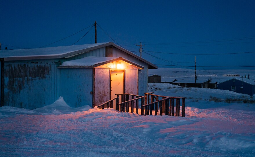A home with the front light on in Toksook Bay.