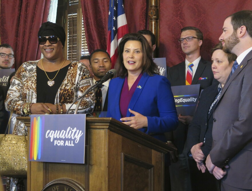 Michigan Gov. Gretchen Whitmer, center, joins with lawmakers and others calling for expanding the state's civil rights law to prohibit discrimination against LGBT people on Tuesday, June 4, 2019, in the Capitol building. By David Eggert, AP