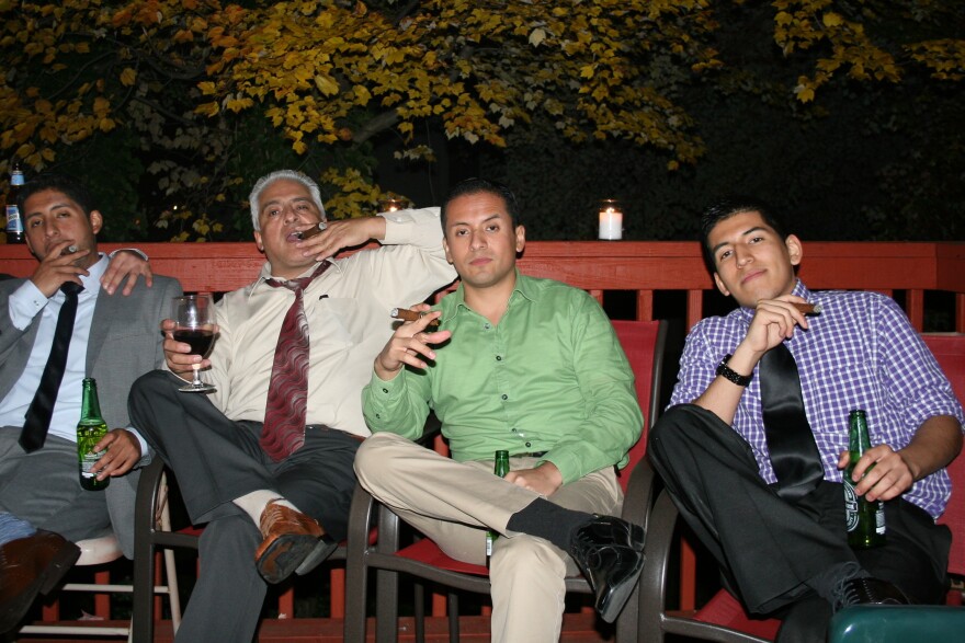 Victor Alarcon Sr. smokes a cigar with his three sons Alvaro (left), Victor Jr. and Miguel. The elder Alarcon emigrated from Bolivia in the 1980s.