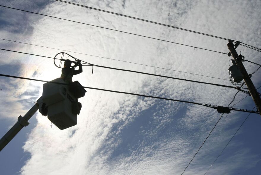 In this Oct. 2, 2007 file photo, A.J. Bowen of Schupp's Line Construction, Inc. works on fiber-optic installation in Norton, Vt.