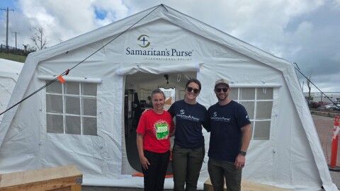 Samaritan’s Purse medical director Lauren Ralston stands between colleagues outside a field hospital tent set up near the Commonwealth Healthcare Corporation on Saipan.