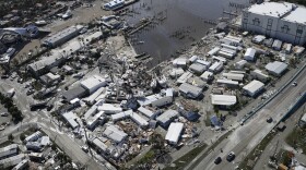 Damaged boats lie on the land and water in the aftermath of Hurricane Ian, Thursday, Sept. 29, 2022, in Fort Myers, Fla. (AP Photo/Wilfredo Lee)
