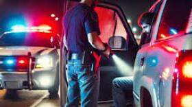 image of a traffic stop, police officer seen holding a flashlight