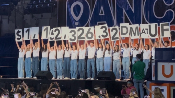 Organizers for the Dance Marathon at the University of Florida hold up signs revealing the total amount raised during the 26.2-hour event on March 28 and 29. (Victor Torres/WUFT News)