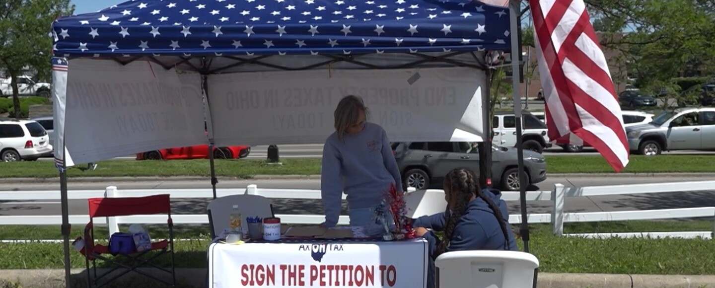 Central Ohio region captain Sue Mazzarini manages the booth at a signing event to abolish property taxes in Ohio.