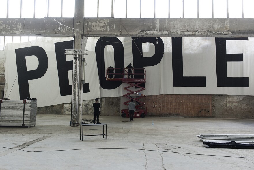 Workers hang a banner at the Funkhaus in Berlin.