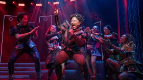 Performers from six the musical sing on stage
