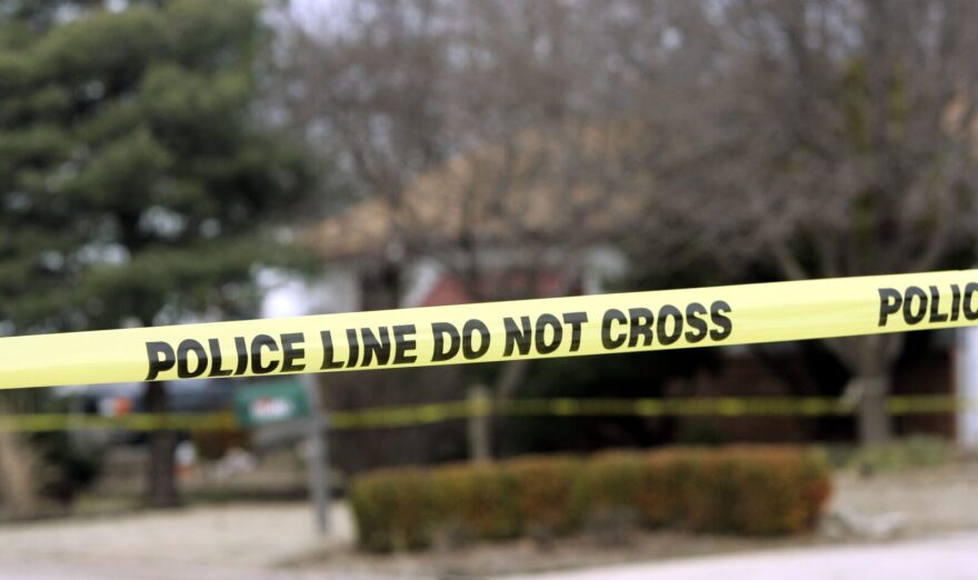 Police tape hangs across the street in front a house in Park City, Kansas. 