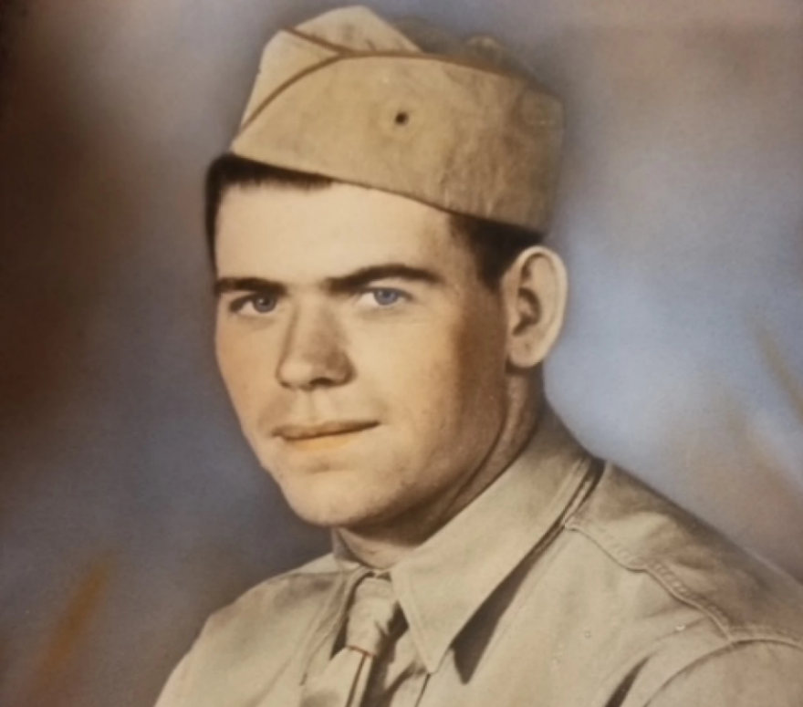 An old photo of a military service member in khaki uniform.