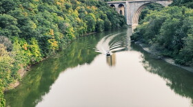 A boat in the Genesee River heading away from the trail bridge