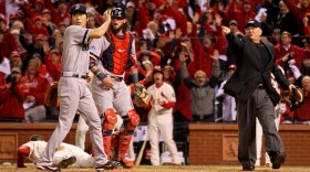 Home plate umpire Dana DeMuth points to third base, where an obstruction call awarded the St. Louis Cardinals' Allen Craig home plate — and the winning run in Game 3 of the World Series — Saturday night. Boston Red Sox catcher Jarrod Saltalamacchia and Koji Uehara were dismayed by the call.