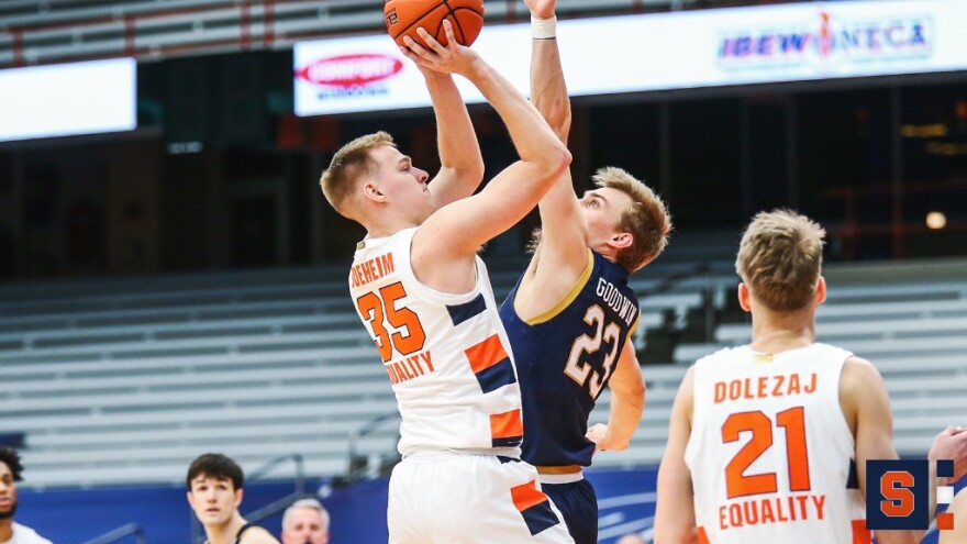 Syracuse’s Buddy Boeheim (#35, white) attempts a shot against the outstretched arm of Dane Goodwin (#23, blue).