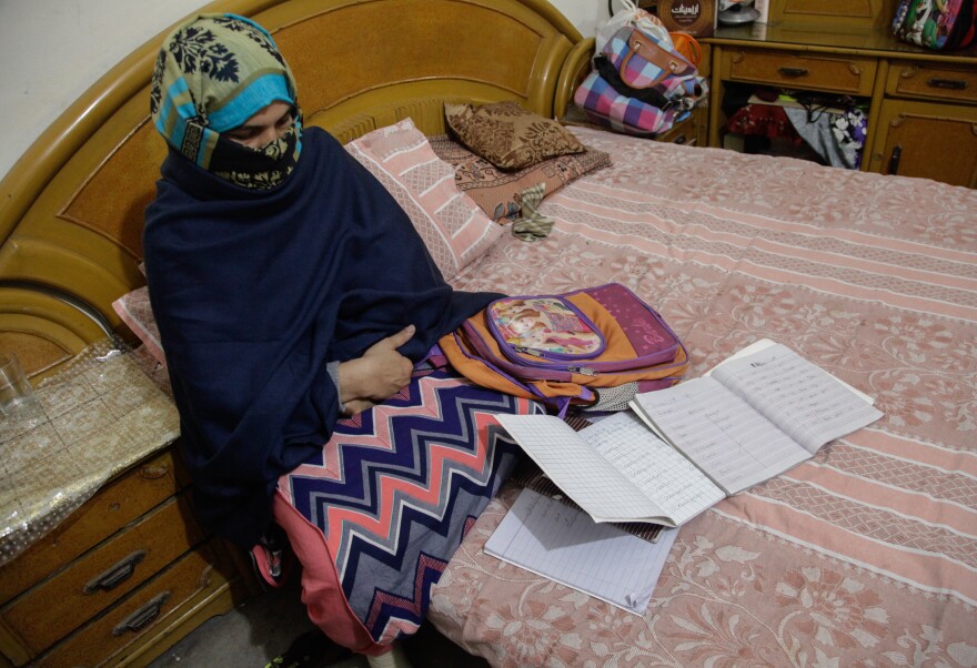 Zainab's mother, Nusrat Amin, sits with her slain daughter's school bag and notebooks.