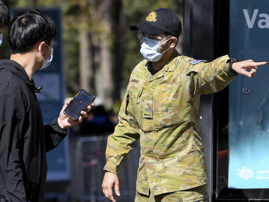 Australian Defense Force personnel assist the public at a COVID-19 vaccination clinic in Sydney, Wednesday, Aug.18th. Australia's most populous state reported a record 633 new infections on Wednesday.