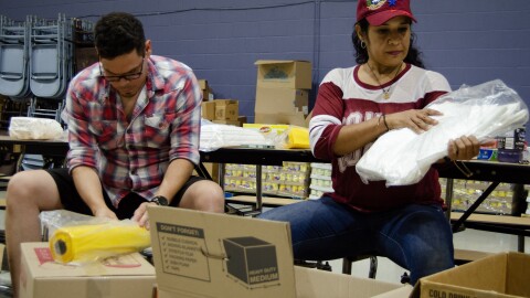 Gustavo Perez and Yosybel Alfonzo help sort through donations in Kansas City to support victims of the massive earthquakes in Venezuela last month.