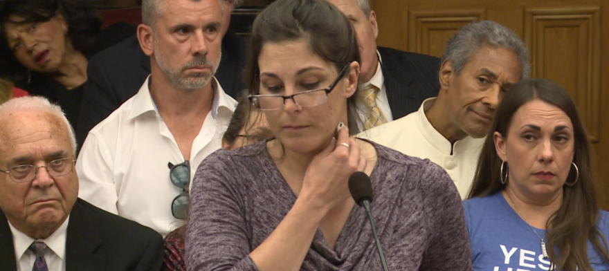 Joanna Overholt attempts to stick a key to her neck in testimony on COVID vaccines before the Ohio House Health Committee on June 8, 2021. The key fell off her neck.