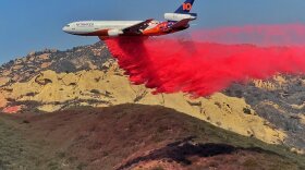 A DC-10 air tanker drops fire retardant near the Las Flores oil facility on the Gaviota Coast, to protect it from the Alisal wildfire.