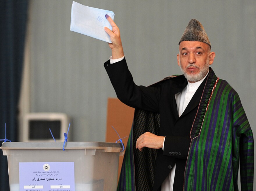 Afghan President Hamid Karzai gestures before casting his vote at a polling station in Kabul, Sept. 18, 2010, in parliamentary elections that were marred by allegations of fraud.