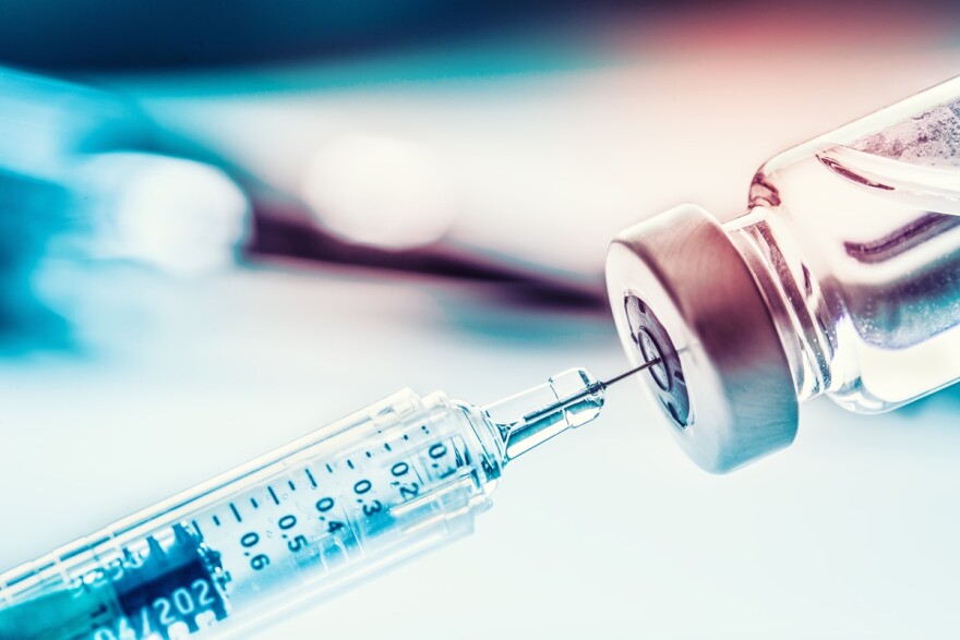 Close-up medical syringe with a vaccine vial.