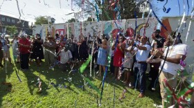 Community leaders, nonprofit heads, and county commissioners celebrate the West Side Community Land Trust's announcement.