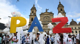 People hold up letters that form the word "Peace" in Spanish during a gathering at Bolivar square in Bogota, Colombia, Monday, Sept. 26, 2016. (Jennifer Alarcon/AP)