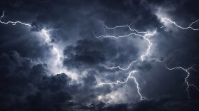 Powerful lightning bolts cutting through dark storm clouds in a night sky, capturing intense weather, atmospheric energy, and a severe thunderstorm.